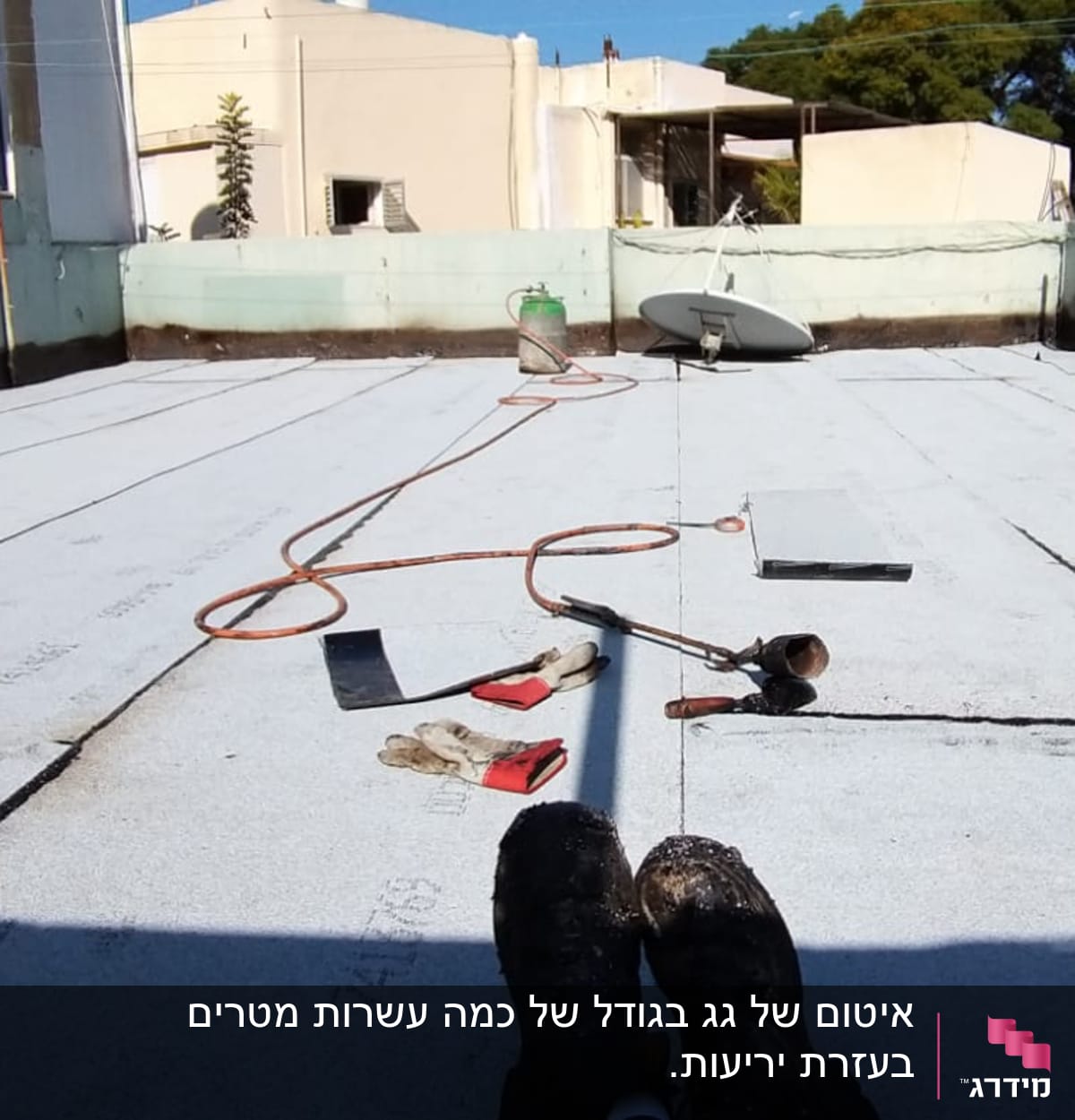 גג עם יריעות איטום, כלי עבודה וצינור גז